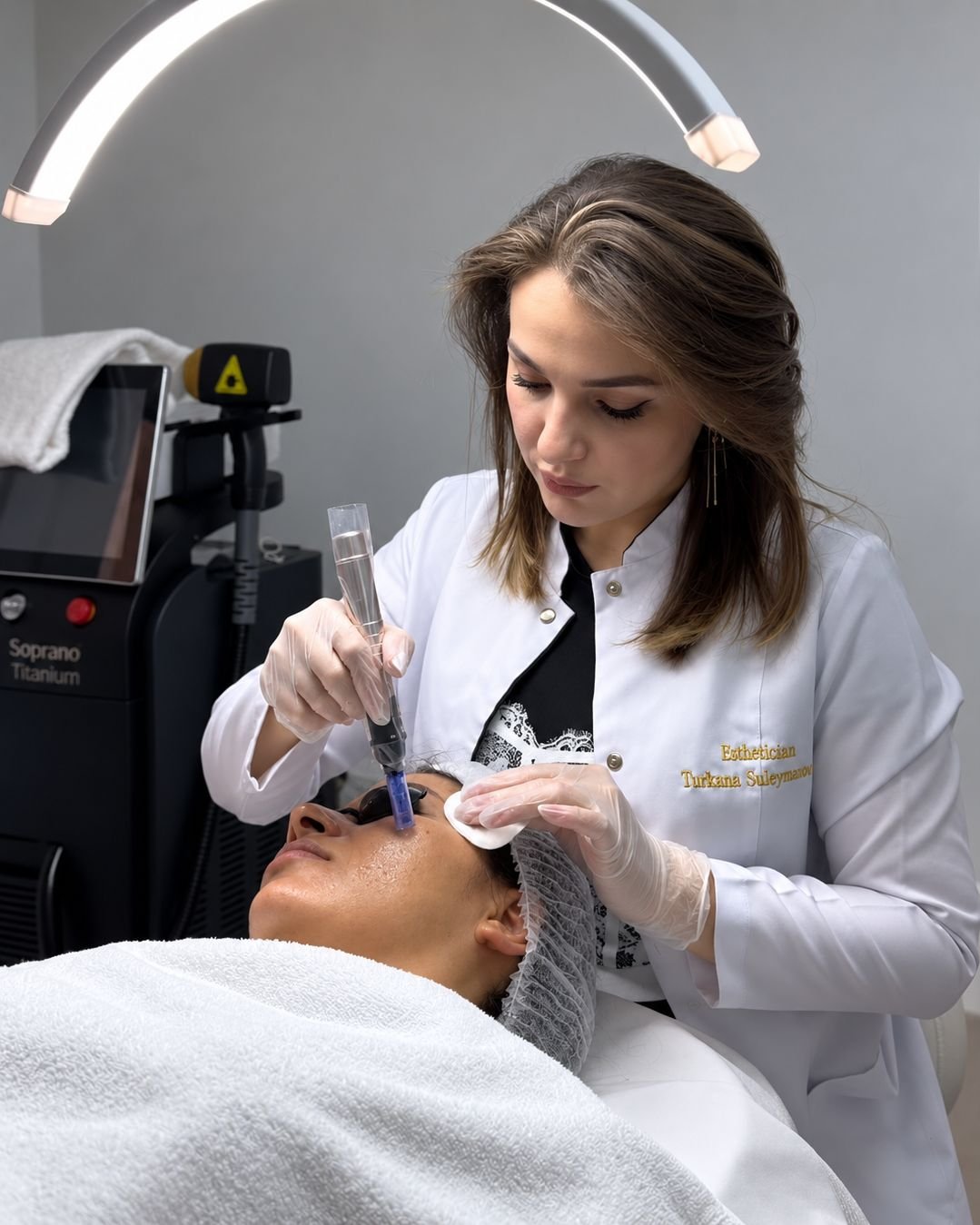 Esthetician Turkana Suleymanova in the studio, with the Soprano Titanium laser behind her